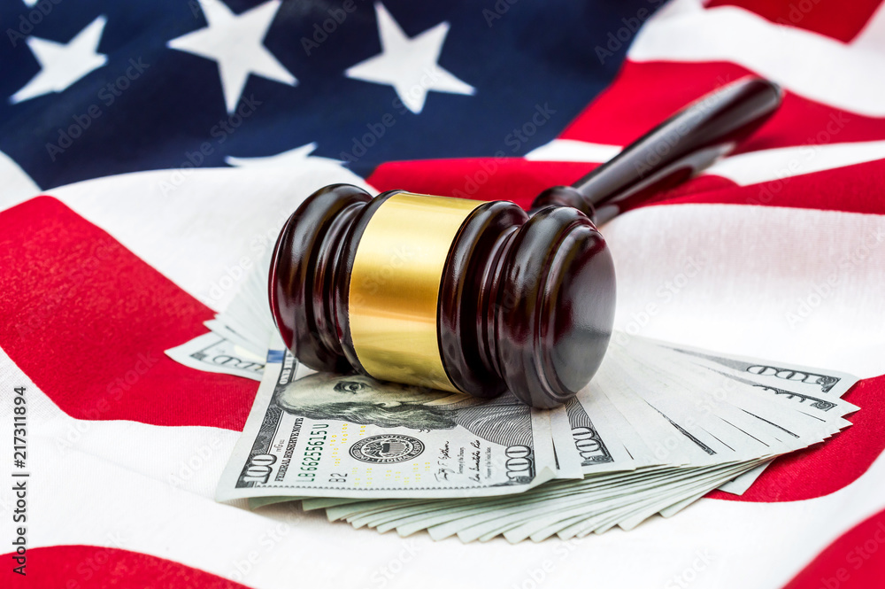 Gavel with money on american flag.