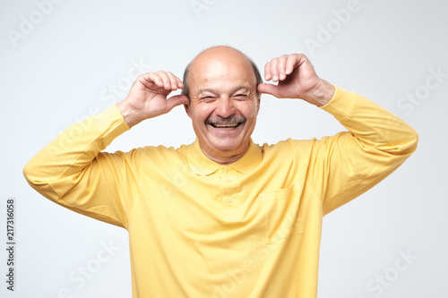 Mature adult man with moustache laughing looking at the camera over white background. Some jokes are old but gold photo