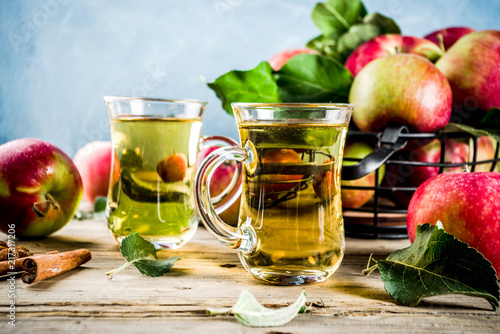 Homemade apple cider with cinnamon and anise spices  with fresh apples on wooden rustic background copy space