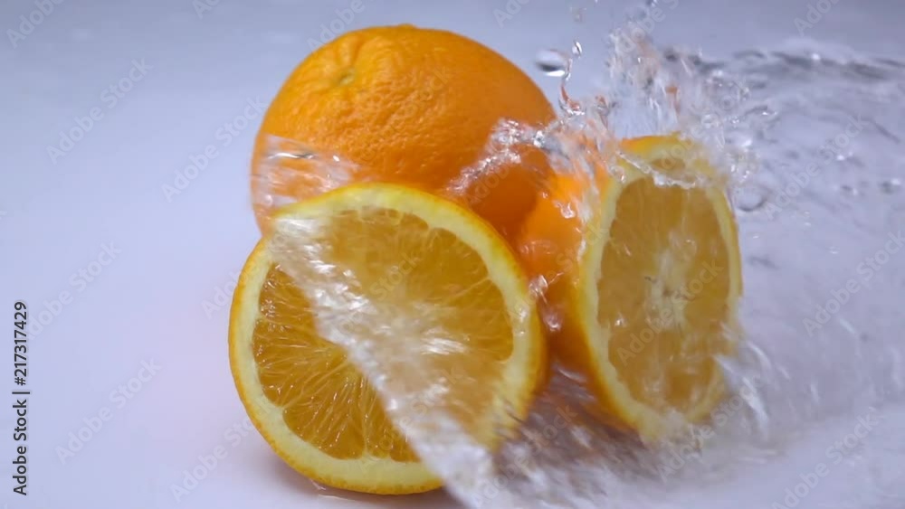 water splashing on an orange fruit in slow motion. water splashing on an orange fruit in slow motion.