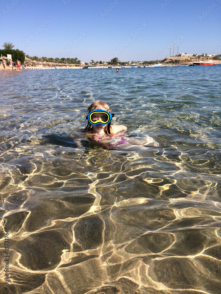 vacation at sea. a girl of European appearance swims in the sea with a mask.