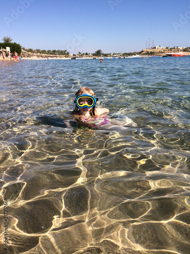 vacation at sea. a girl of European appearance swims in the sea with a mask.