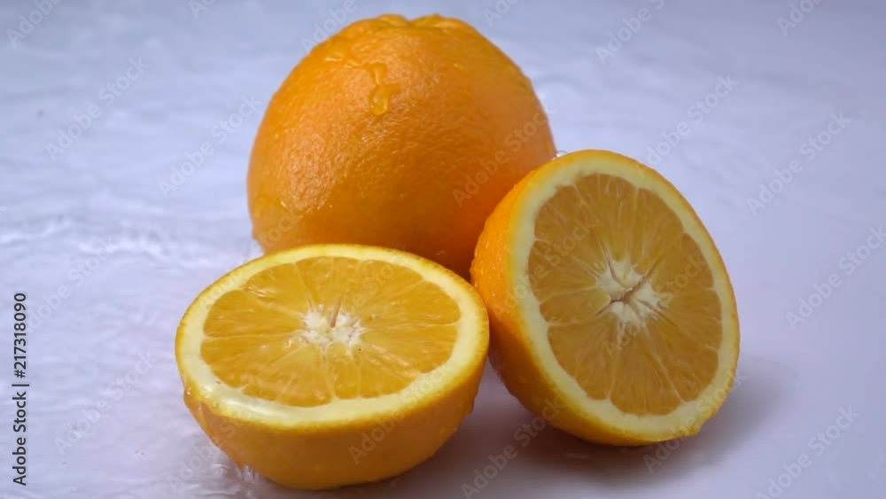 water splashing on an orange fruit in slow motion. water splashing on an orange fruit in slow motion.