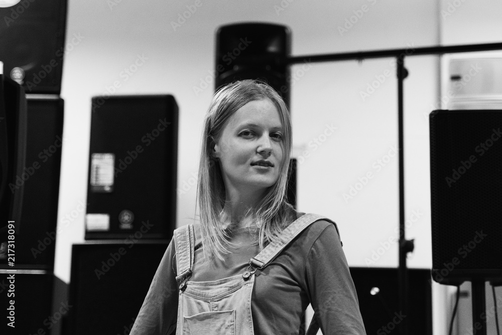 street photo in the style of an old black and white film with grain - modern woman posing in a music store street photo in the style of an old black and white film with grain - modern woman posing in a music store