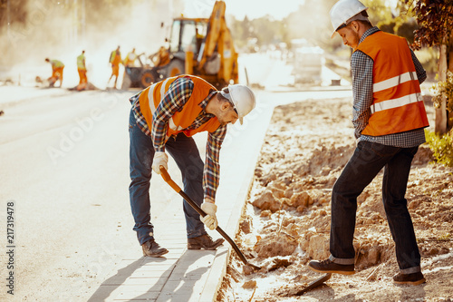 Canvas Print Workers in reflective vests using shovels during carriageway work