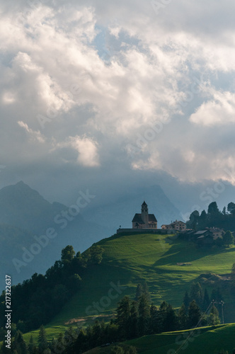 The Church in the village of Colle Santa Lucia in the Golden hours, just before sunset. Italian Dolomites on a summer's evening.