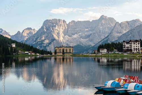 Buildings along the shoreline are reflected in the calm waters of Lake Misurina in the Italian Dolomites  just before sunset.