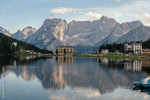 Buildings along the shoreline are reflected in the calm waters of Lake Misurina in the Italian Dolomites  just before sunset.