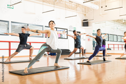 Clients Performing Warrior Pose Ii On In Health Club