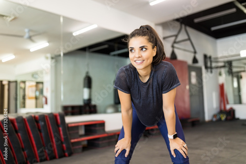 Smiling Female Athlete Relaxing After Exercise In Gym