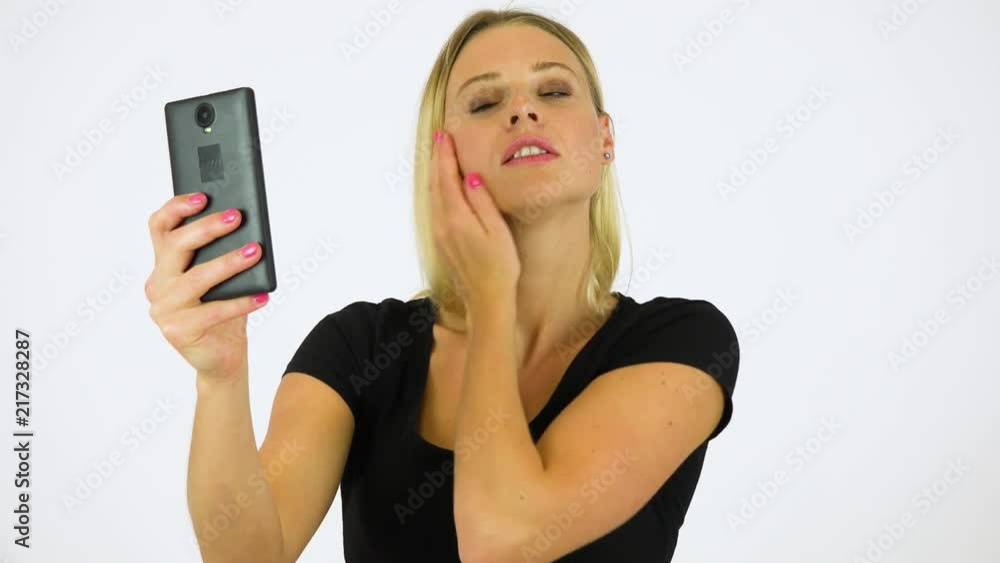 A young beautiful woman takes selfies with a smartphone - white screen studio A young beautiful woman takes selfies with a smartphone - white screen studio