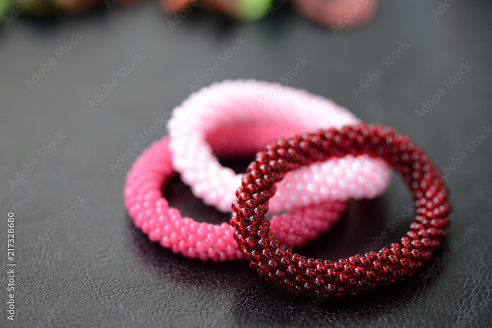 Set of three beaded children's bracelets on a dark background close up