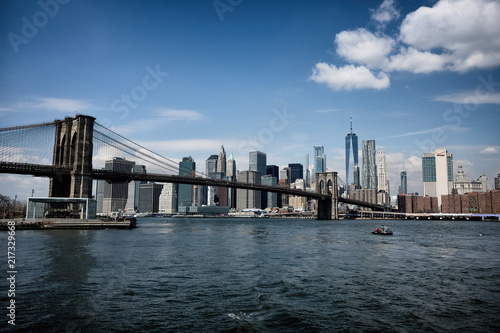 Fototapeta Naklejka Na Ścianę i Meble -  Brooklyn bridge with New York City skyline panoramic spring view. Lower Manhattan downtown scenery from Brooklyn Bridge Park riverbank in Dumbo district, NYC, USA.