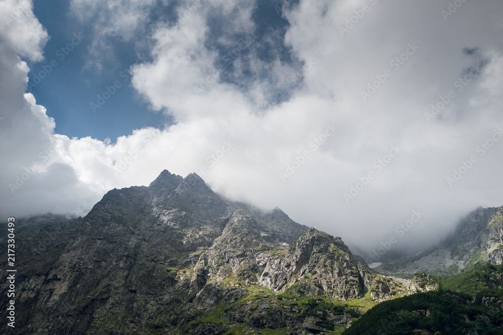 Scenic view of beautiful rocky mountain hills and peaks covered by clouds. Marine Eye lake, High Tatras, Zakopane, Poland. Foggy day