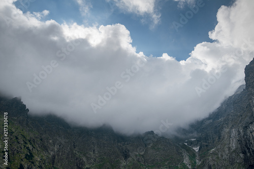 Scenic view of beautiful rocky mountain peaks covered by clouds. Marine Eye lake  High Tatras  Zakopane  Poland. Foggy day