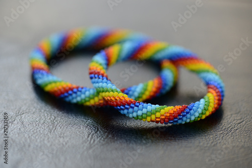 Set of rainbow bracelets for mother and daughter on a dark background close up