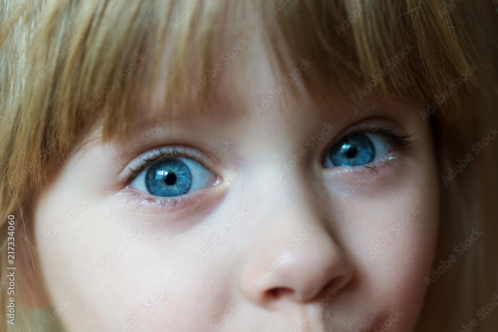 portrait of a little blonde girl with blue eyes and a sly look portrait of a little blonde girl with blue eyes and a sly look