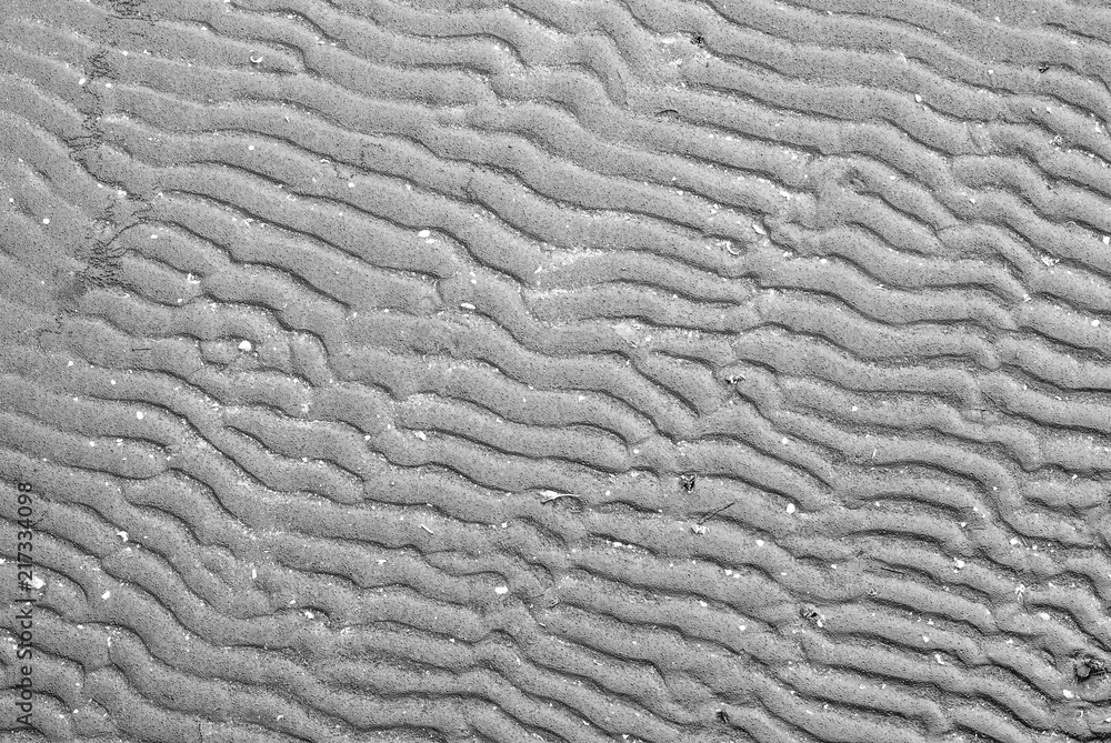Black wet beach sand form in curve-line pattern for abstract background, nature beauty Black wet beach sand form in curve-line pattern for abstract background, nature beauty