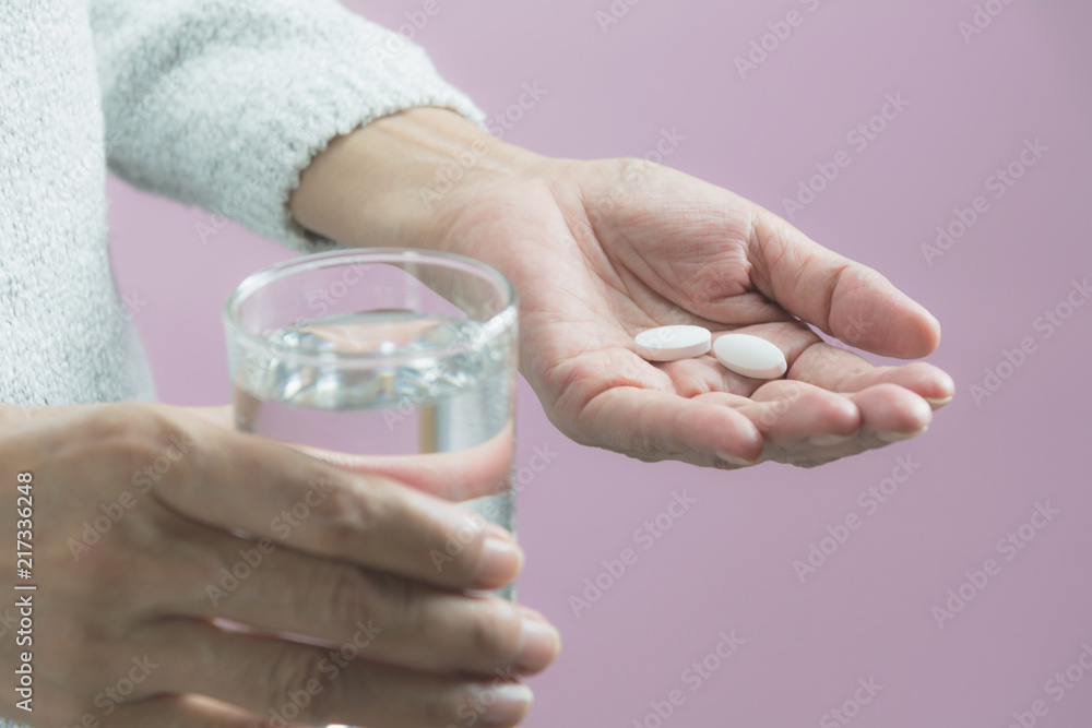 Taking medicine pills. Woman holds in hands the medicine pills and a glass of water. Healthcare concept. Taking medicine pills. Woman holds in hands the medicine pills and a glass of water. Healthcare concept.