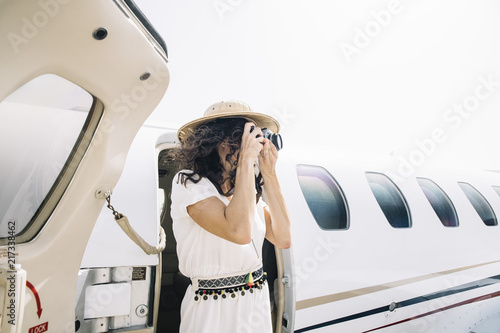 Pretty woman lowers an outdoor airplane and takes photos. photo