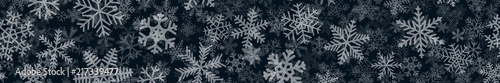 Christmas horizontal seamless banner of many layers of snowflakes of different shapes, sizes and transparency. White on black.
