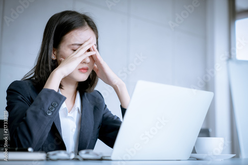 Asian business woman headache stressed because of work mistake problems about profit losses to be risk for fired from her job