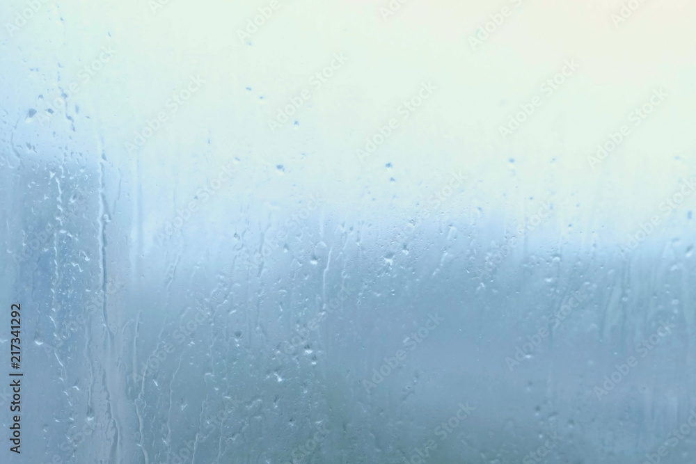 Raindrops flow down the glass close-up indoor Raindrops flow down the glass close-up indoor
