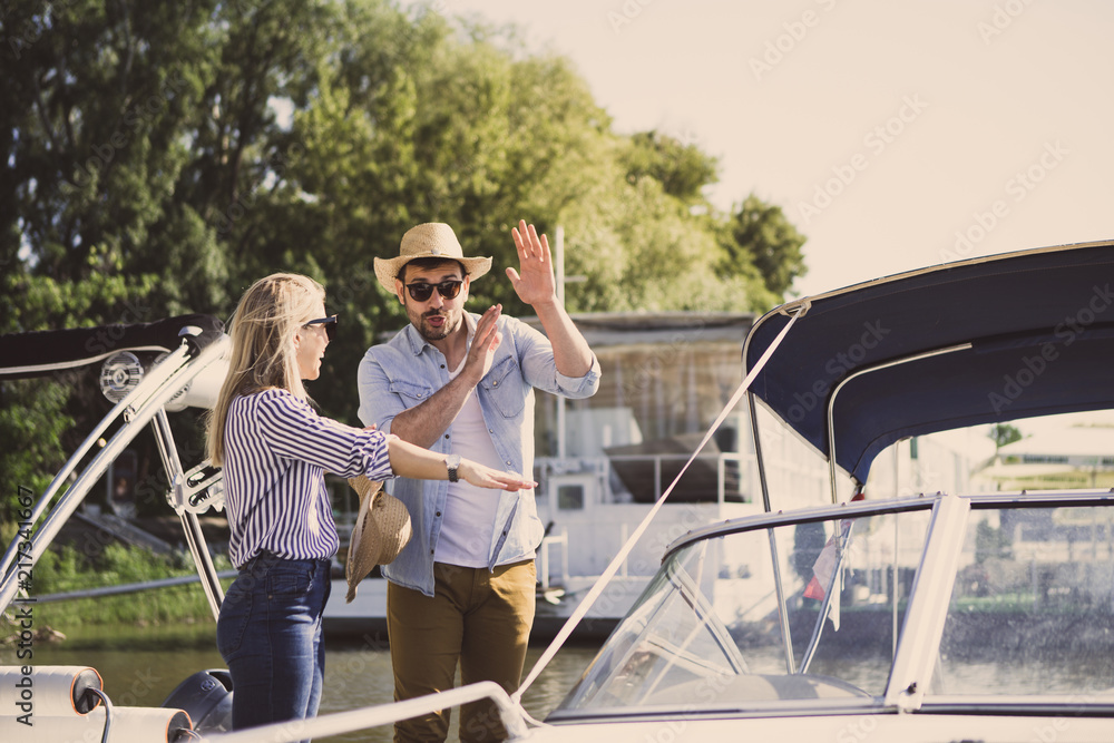 A handsome young man explains a beautiful blonde that she must be careful because she can fall out of the speedboat when it speeds up. A handsome young man explains a beautiful blonde that she must be careful because she can fall out of the speedboat when it speeds up.