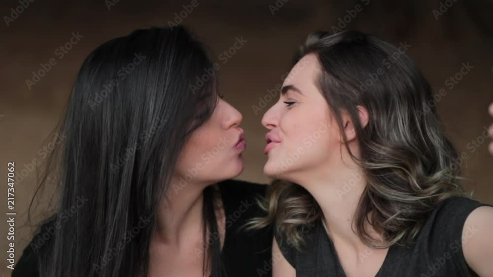 LGBT lesbian couple kissing while taking a selfie with cellphone Stock ビデオ | Adobe Stock