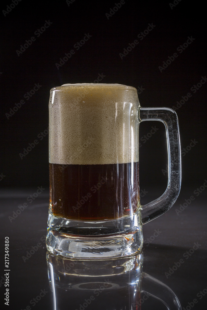Mug of black beer, Glass of dark beer on black background, Beer glass with dark cold beer, Pint glass with dark stout with bubble froth Mug of black beer, Glass of dark beer on black background, Beer glass with dark cold beer, Pint glass with dark stout with bubble froth