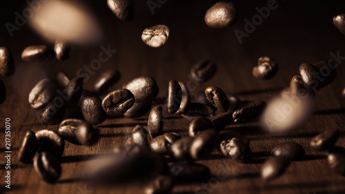 Falling coffee beans on a wooden table