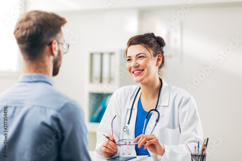 Woman Doctor talking to Patient at her Medical Office photo