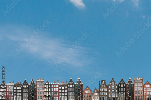 Traditional houses in Amsterdam in the Netherlands in a row against the blue sky.