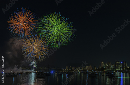 night fireworks over the ocean with floating yachts and ships