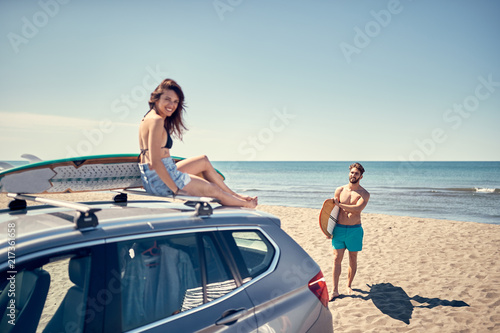Surfing. Summer Vacation. Extreme Sport. surfer girl sitting on the car and getting ready for surfing. © luckybusiness
