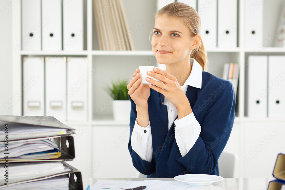 Happy business woman or female accountant having some minutes for coffee and pleasure at working place Happy business woman or female accountant having some minutes for coffee and pleasure at working place