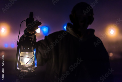 Man in the dark with a kerosene lamp