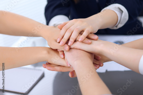 Group of business people joining hands, close-up. Teamwork, cooperation and success concept of communication