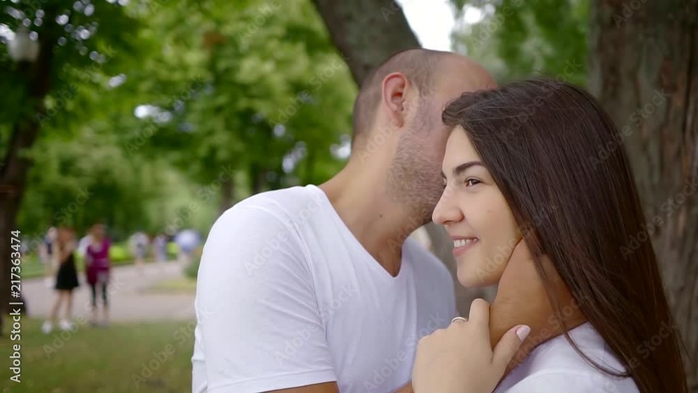 Close up portrait of a loving couple cuddling under a tree in a park. Close up portrait of a loving couple cuddling under a tree in a park.