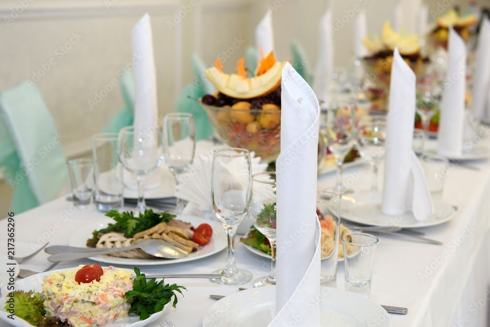 Exquisite table with food and covered with white tablecloth. Luxury feast at the Banquet. 