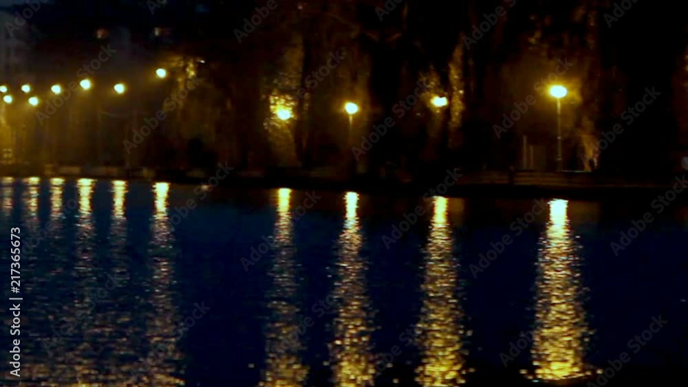 blurred light of the night lights on the embankment is reflected in the river water. Defocused view blurred light of the night lights on the embankment is reflected in the river water. Defocused view
