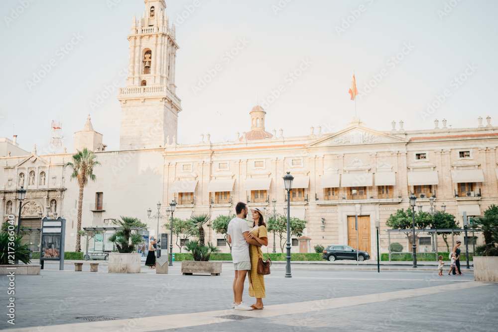 Beautiful young brunette woman with her boyfriend with beard dancing in the street in Spain in the evening