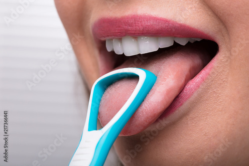 Woman Cleaning Her Tongue With Cleaner