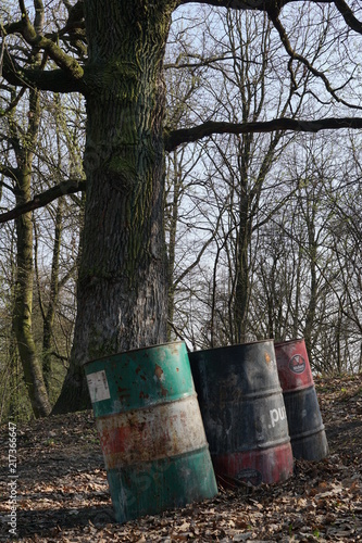 beczki z chemikaliami w wiosennym lesie, dzikie wysypiska śmieci w lesie, utylizacja szkodliwych chemikaliów