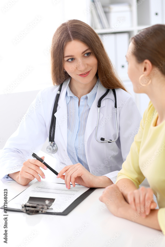 Doctor and patient sitting at the desk near window Doctor and patient sitting at the desk near window