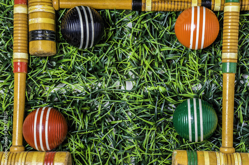 Valokuva green grass framed with wooden croquet mallets and balls with room for copy in t