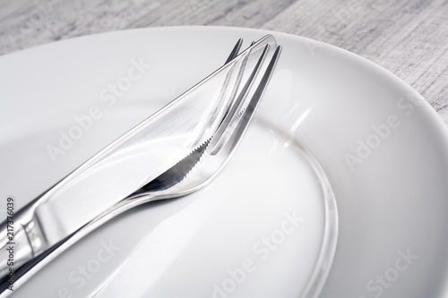Set Of Crossed Stainless Steel Fork And Knife On A Dinner Plate