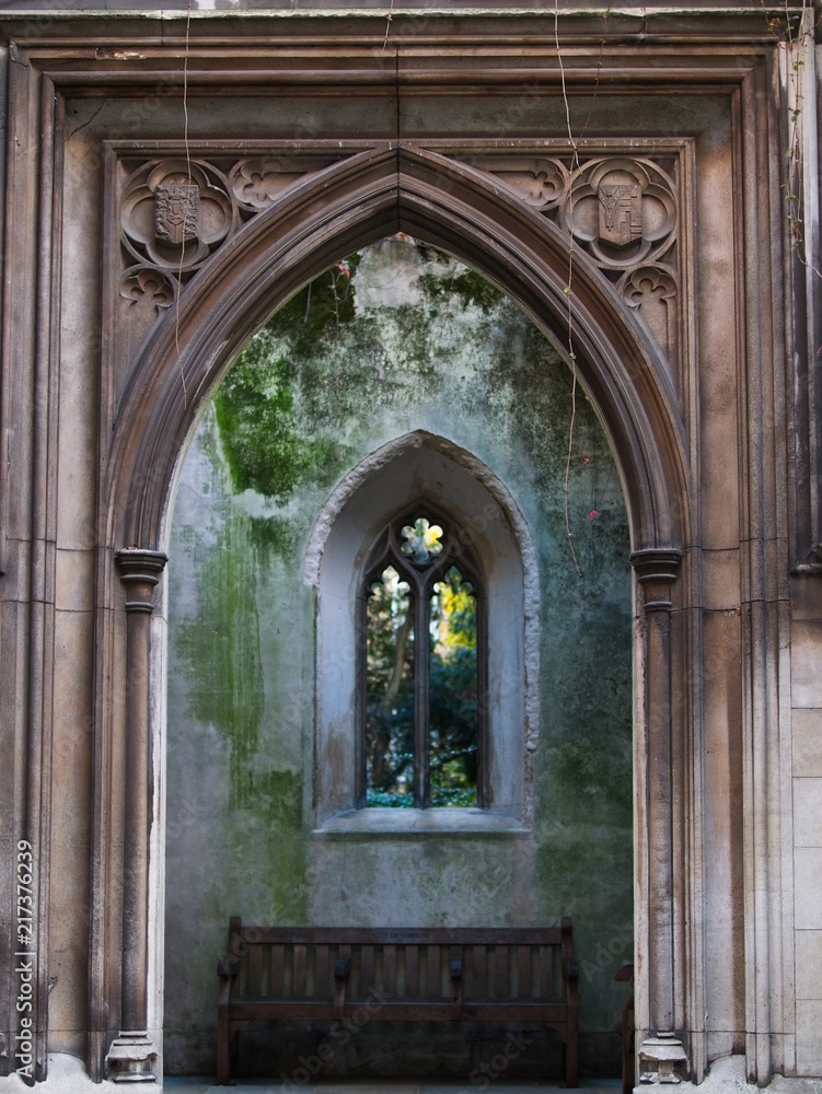 Gothic facade and gate with wooden bench. 
