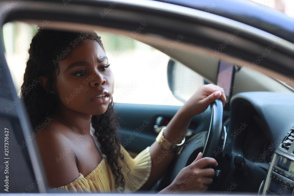 Cautious black woman driving car