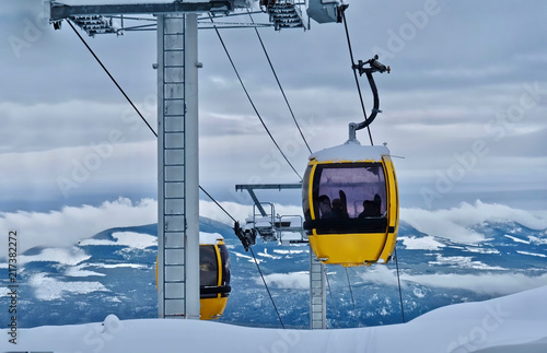 Gondola at ski resort. Chair lift with view of snowy mountains. Beautiful winter day at Big White Ski Resort. Kelowna. British Columbia. Canada.